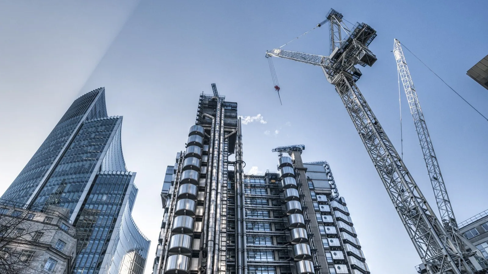 Glass towers and construction cranes